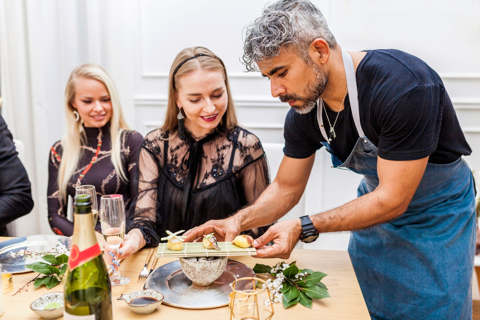 Latin cook serving food to clients during private dinner